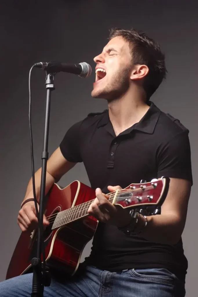 Man singing and playing on a guitar